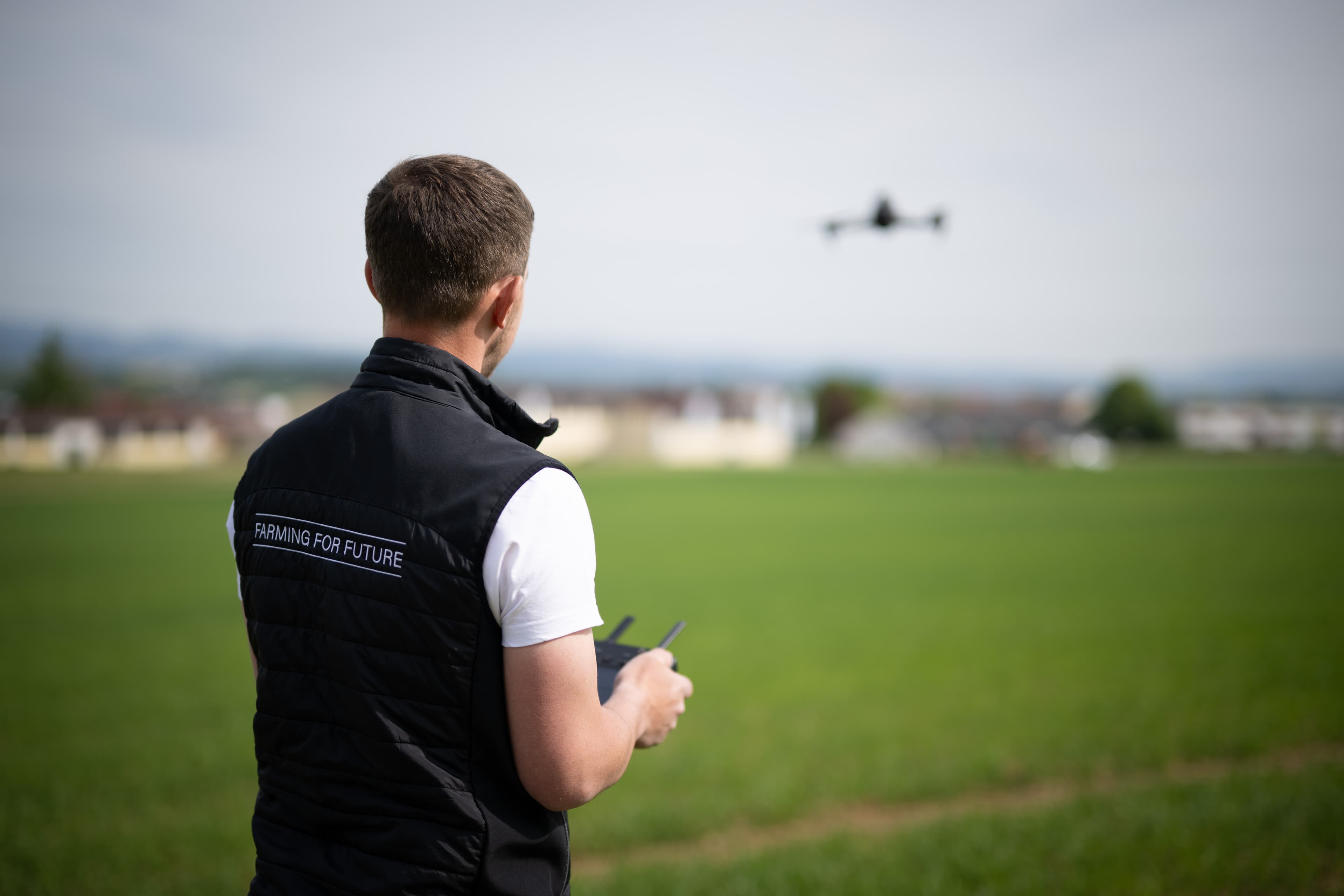 Mitarbeiter der Innovation Farm mit Drohne auf dem Feld